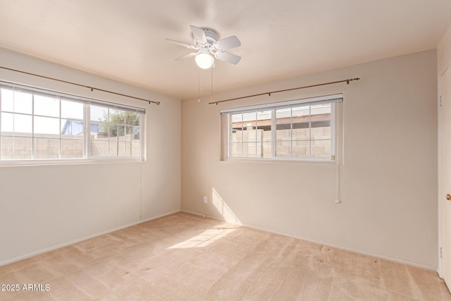 carpeted spare room with plenty of natural light and ceiling fan