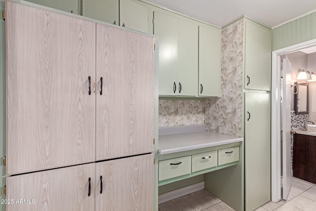 interior space with tasteful backsplash, light tile patterned flooring, and sink