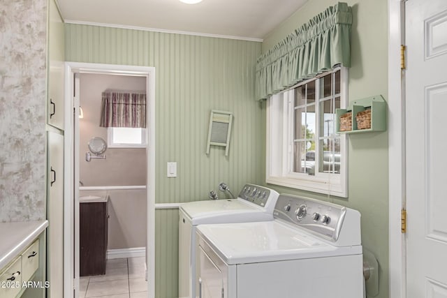 washroom with light tile patterned flooring, independent washer and dryer, crown molding, and cabinets