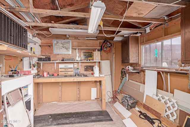 basement featuring wooden walls and a workshop area