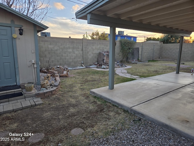 yard at dusk with a patio area