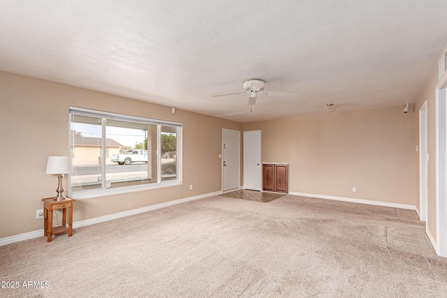 carpeted spare room featuring ceiling fan and a textured ceiling