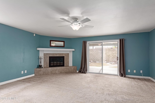 unfurnished living room featuring a tiled fireplace, carpet, and ceiling fan