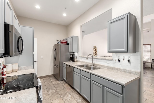 kitchen featuring appliances with stainless steel finishes, sink, and gray cabinetry