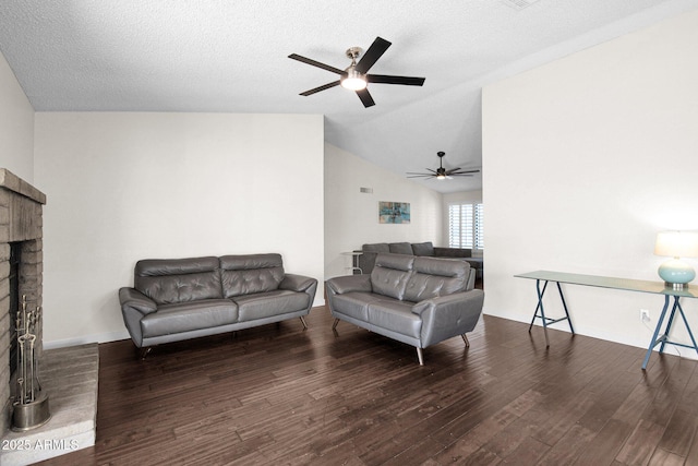 living area featuring a textured ceiling, wood finished floors, a fireplace, baseboards, and vaulted ceiling