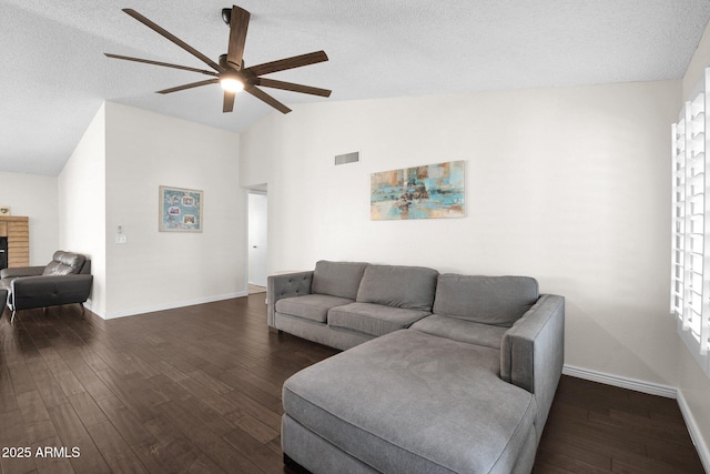 living room featuring dark wood finished floors, visible vents, a fireplace, and baseboards