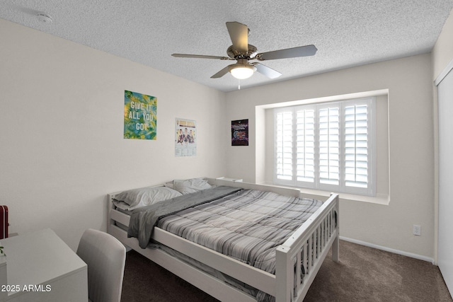 carpeted bedroom with a textured ceiling, baseboards, and a ceiling fan