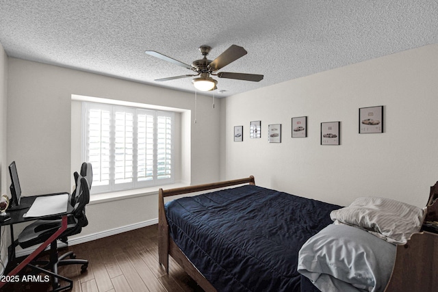 bedroom with ceiling fan, a textured ceiling, baseboards, and wood finished floors