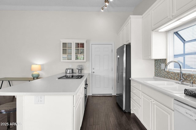 kitchen featuring light countertops, appliances with stainless steel finishes, a peninsula, white cabinetry, and a sink