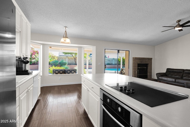 kitchen with dark wood-type flooring, appliances with stainless steel finishes, light countertops, and white cabinetry