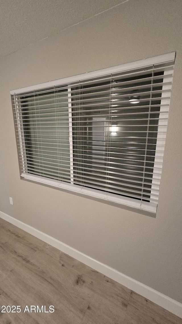 interior details featuring wood finished floors and baseboards