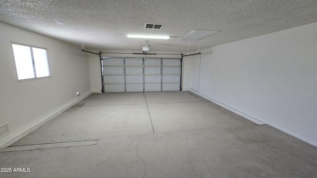 garage with visible vents, a garage door opener, and baseboards
