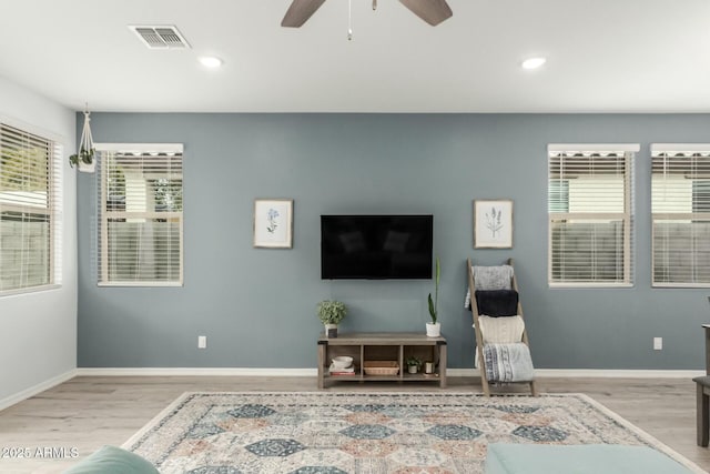 living room featuring ceiling fan and light hardwood / wood-style flooring