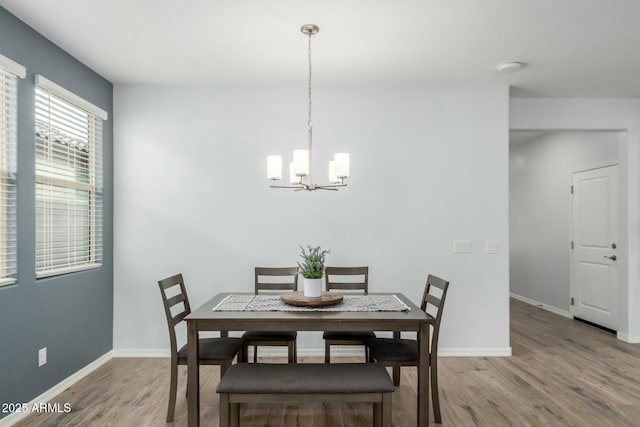 dining space with a notable chandelier and light wood-type flooring