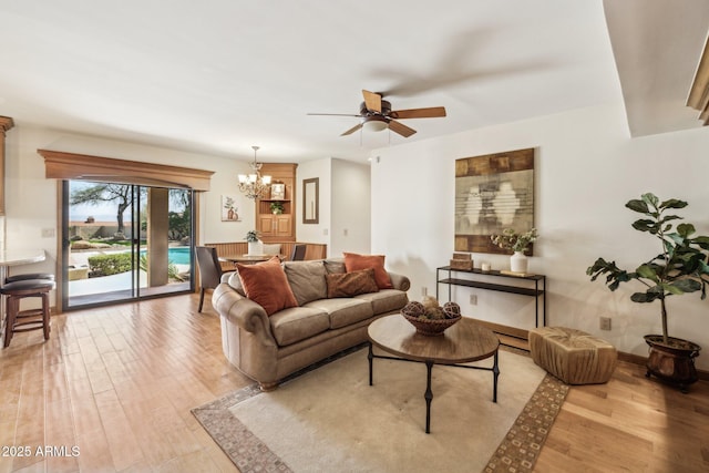 living room with wood finished floors and ceiling fan with notable chandelier