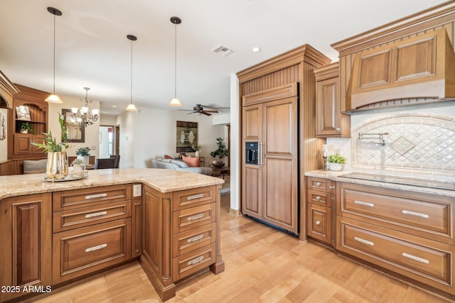 kitchen featuring paneled fridge, brown cabinets, visible vents, and black electric cooktop