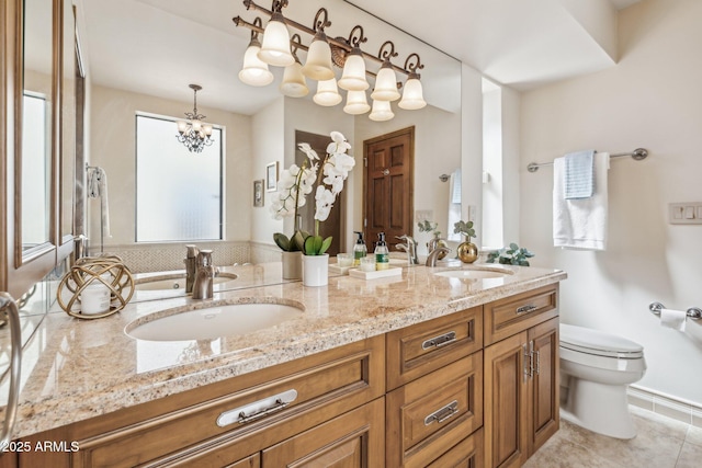 bathroom with an inviting chandelier, a sink, toilet, and double vanity