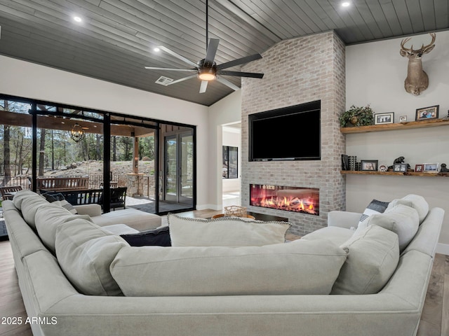 1137 Timbernook Xing, Williams, AZ 86046 - living area featuring wood finished floors, a ceiling fan, a fireplace, lofted ceiling, and recessed lighting