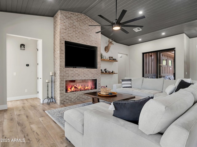 1137 Timbernook Xing, Williams, AZ 86046 - living room featuring a brick fireplace, wooden ceiling, light wood-style floors, baseboards, and vaulted ceiling