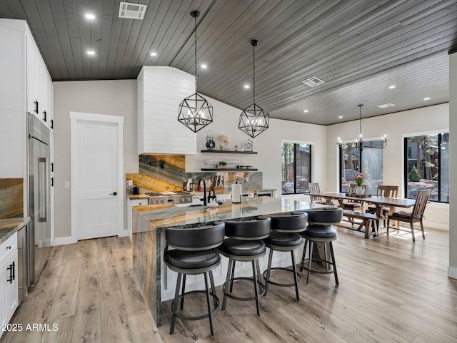 1137 Timbernook Xing, Williams, AZ 86046 - kitchen featuring a kitchen island, a chandelier, healthy amount of natural light, white cabinets, and lofted ceiling
