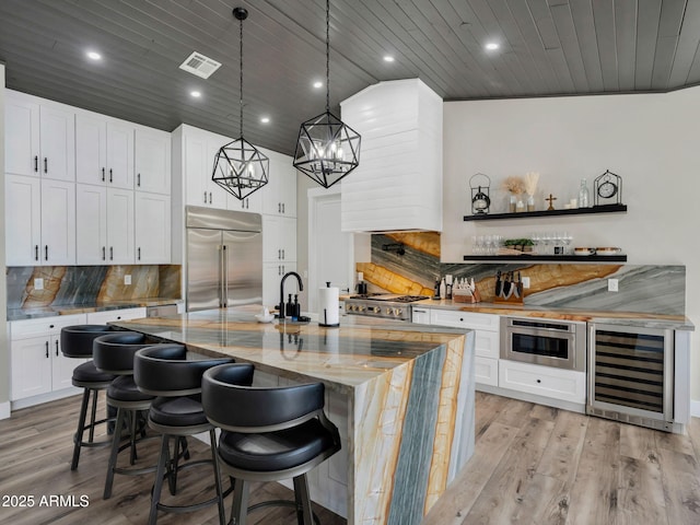 1137 Timbernook Xing, Williams, AZ 86046 - kitchen with built in appliances, beverage cooler, wooden ceiling, light wood-style flooring, and tasteful backsplash