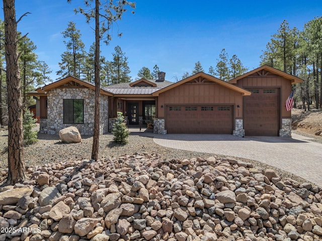 1137 Timbernook Xing, Williams, AZ 86046 - view of front of home with stone siding, an attached garage, decorative driveway, board and batten siding, and a chimney
