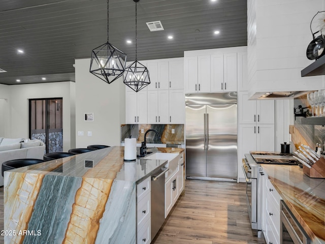 1137 Timbernook Xing, Williams, AZ 86046 - kitchen with high quality appliances, a sink, light wood finished floors, a chandelier, and white cabinets