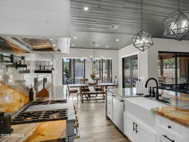 1137 Timbernook Xing, Williams, AZ 86046 - kitchen featuring a chandelier, a sink, wooden counters, white cabinetry, and hanging light fixtures