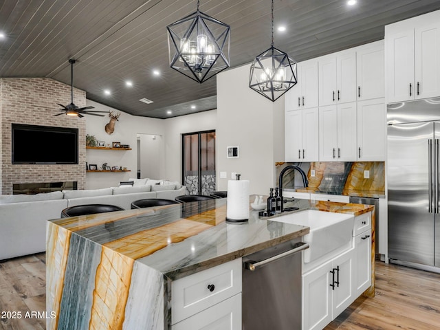 1137 Timbernook Xing, Williams, AZ 86046 - kitchen featuring stainless steel appliances, a sink, light wood-style flooring, open floor plan, and vaulted ceiling