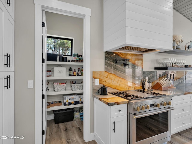 1137 Timbernook Xing, Williams, AZ 86046 - kitchen with high end stainless steel range oven, custom range hood, light wood-style floors, and backsplash