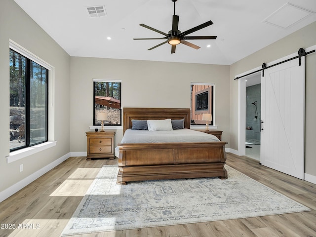 1137 Timbernook Xing, Williams, AZ 86046 - bedroom featuring a barn door, recessed lighting, baseboards, light wood finished floors, and ensuite bath