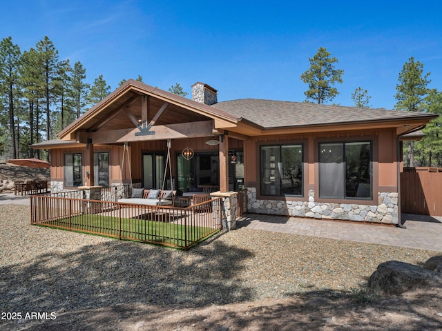 1137 Timbernook Xing, Williams, AZ 86046 - rear view of house featuring a patio, stone siding, a chimney, and roof with shingles