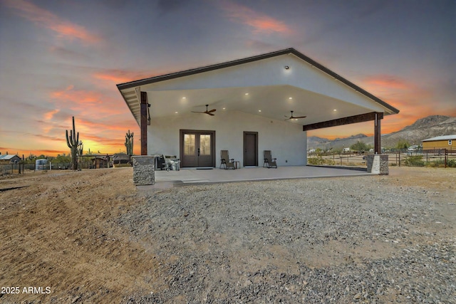 rear view of house featuring a patio area, ceiling fan, fence, and stucco siding