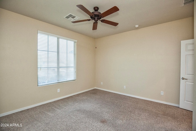 carpeted spare room featuring ceiling fan