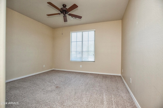 carpeted spare room with ceiling fan