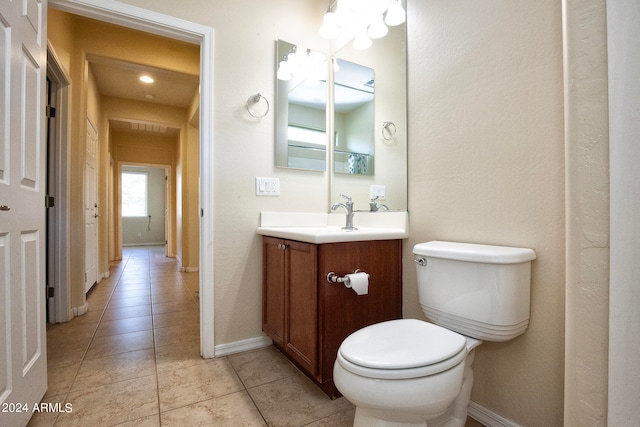 bathroom featuring tile flooring, vanity, and toilet