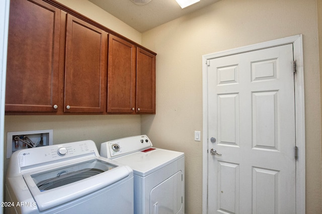 washroom with hookup for a washing machine, separate washer and dryer, and cabinets