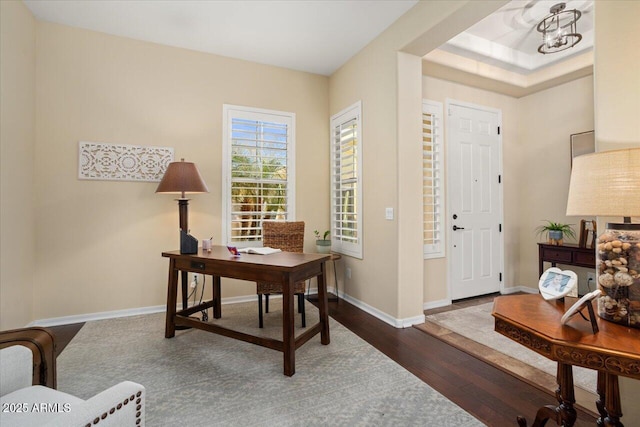 office space with dark wood-type flooring and a notable chandelier