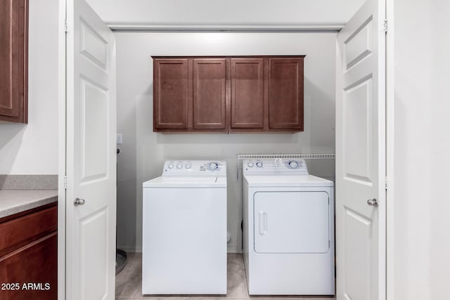 laundry room with cabinets, independent washer and dryer, and light tile patterned floors