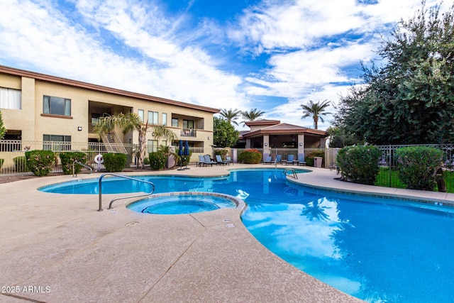 view of swimming pool featuring a patio and a hot tub