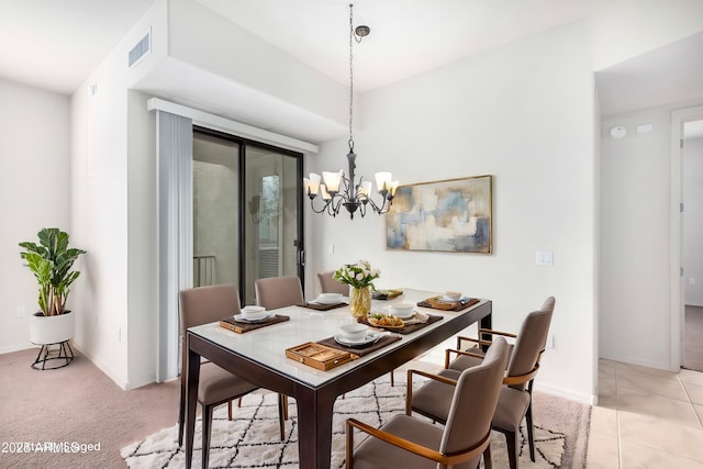 carpeted dining room with a chandelier