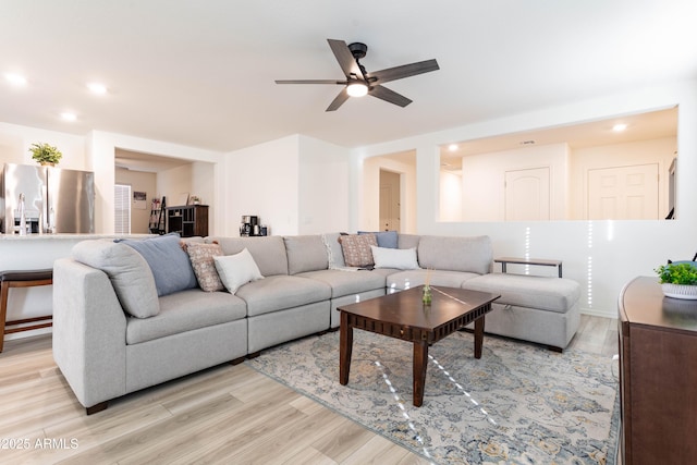 living room featuring ceiling fan and light wood-type flooring