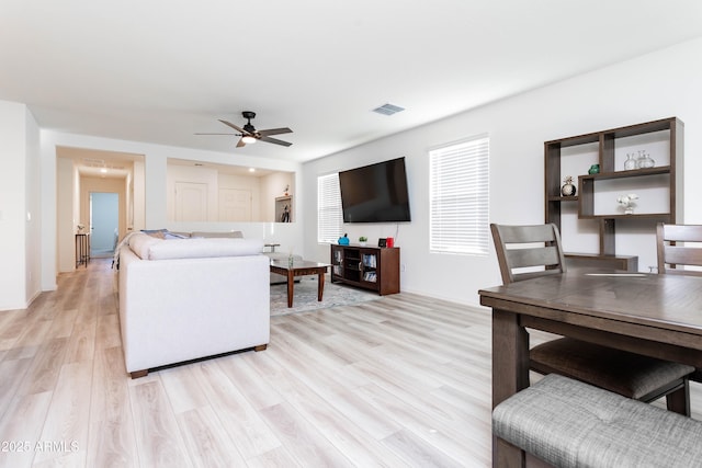 living room with light hardwood / wood-style flooring and ceiling fan