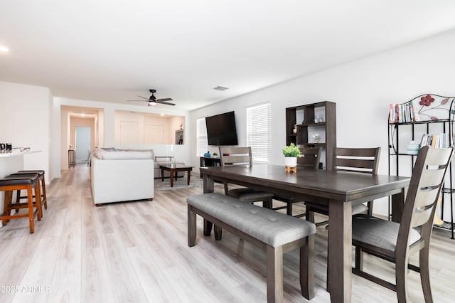 dining room with light hardwood / wood-style floors and ceiling fan