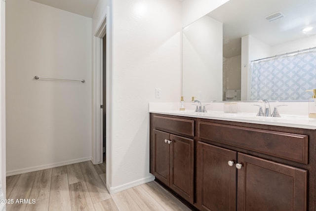 bathroom with hardwood / wood-style flooring, vanity, and a shower with curtain