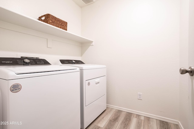 washroom featuring washer and dryer and light hardwood / wood-style floors