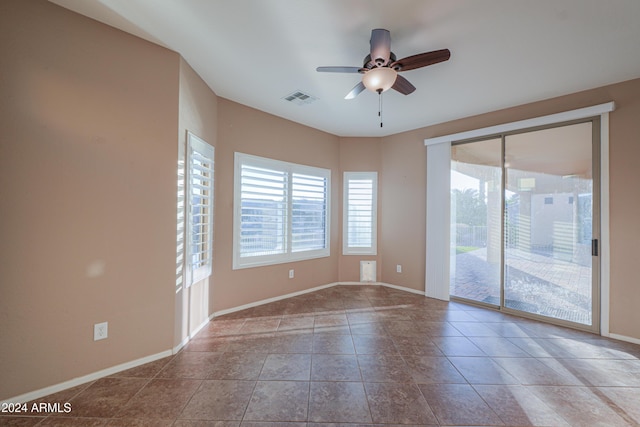 tiled spare room with ceiling fan