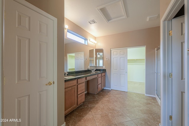 bathroom with tile patterned flooring, vanity, and a shower with door