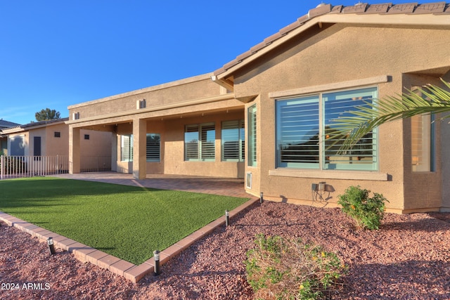 rear view of property featuring a patio area and a yard