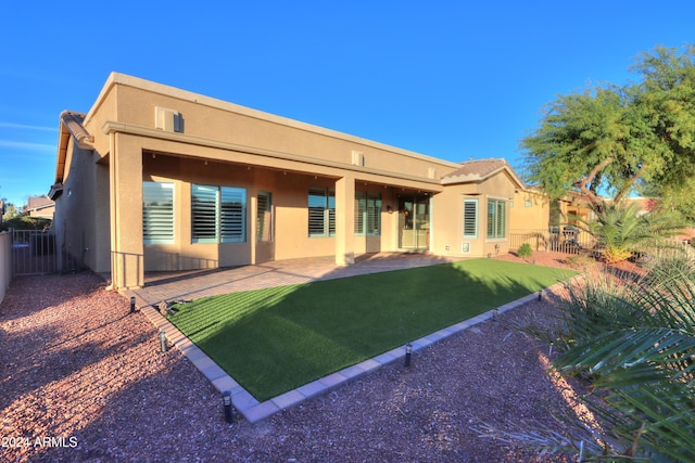 rear view of house with a lawn and a patio